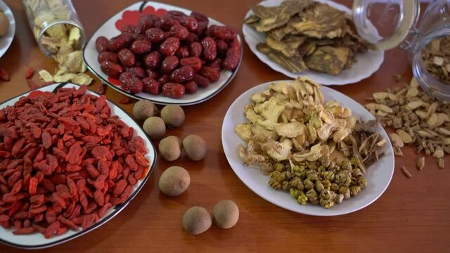 Various Chinese health care herbs on table. Dendrobium, Goji, Longan, Dang Shen, Scutellaria, Red Date, Ginger. Closeup