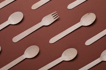 Disposable wooden cutlery on brown background. Single use biodegradable eco-friendly disposable utensils