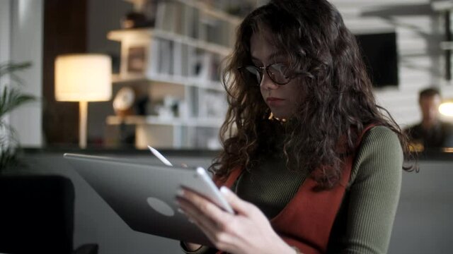 Woman Holding Using Digital Tablet Online Apps At Home Office, Young Ethnic Girl Student Surfing Web Working Studying In Internet. Girl Draws With Pen On Tablet