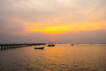 Silhouette small fishing boat in sunset at Bang Phra Beach,sriracha chon buri,thailand