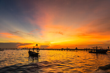 Fototapeta na wymiar Silhouette Small fishing boat at shore in sunset at Bang Phra Beach,sriracha choburi,thailand