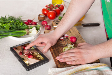 Man preparing vegetable salad at home in the kitchen, close up