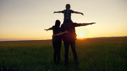 Happy family. Family reunion of mom, dad and son. The child is sitting on the shoulders of the parent's father, arms outstretched, simulating the flight of an airplane.