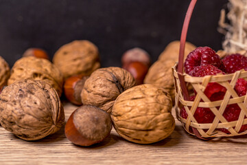 Soft focus, blurring background. Hazelnuts and walnuts. Raspberry wicker basket. Macro.
