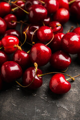 Ripe and juicy cherries on the dark rustic background. Selective focus. Shallow depth of field.
