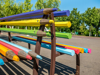 A bench made of big wooden colored pencils.
