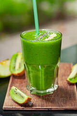 Green kiwi smoothie on a wooden table. Healthy eating.