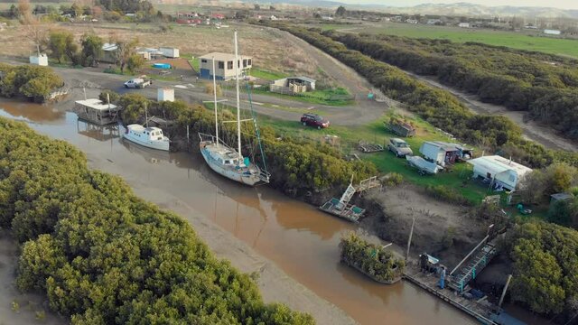 Boats docked in a waterway on the Hauraki Plains, New Zealand