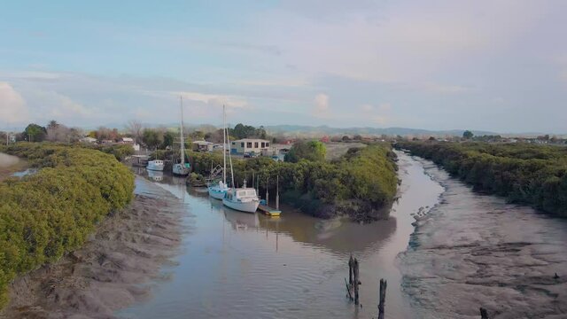Boats docked in a waterway on the Hauraki Plains, New Zealand