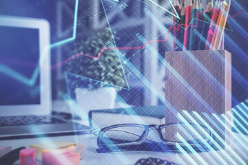 Financial chart hologram with glasses on the table background. Concept of business. Double exposure.
