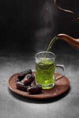 Arab mint tea and dates fruit  on a concrete background