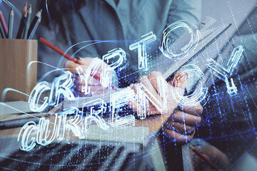 Cryptocurrency hologram over woman's hands writing background. Concept of blockchain. Multi exposure