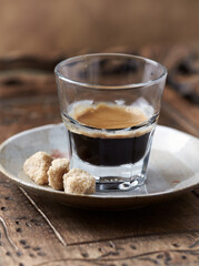 Coffee in glass cup on rustic wooden background. Close up.	