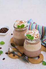 Dessert, two-layer chocolate and coffee panna cotta, decorated with whipped cream.