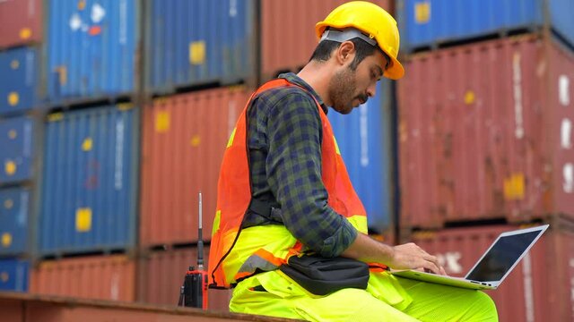 Foreman using laptop computer check Container loading real time monitoring system from cargo freight ship for import export. Logistic, Transportation concept. 