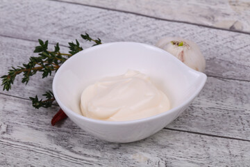 Mayonnaise sauce in the white bowl served thyme and garlic