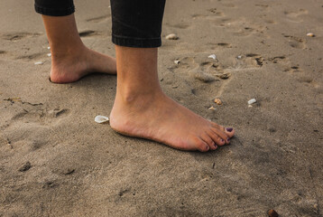 Sandy Feet surrounded by shells on a summers day at the beach