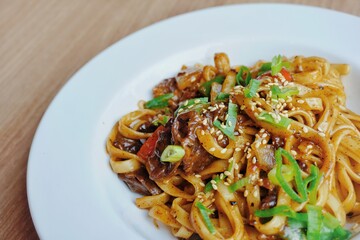 Close up of black pepper fettucini carbonara on a white plate. 