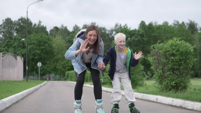 Mom teaches the teen's son to rollerblade. A woman holds a boy's hand and they roll to the meeting camera on roller skates