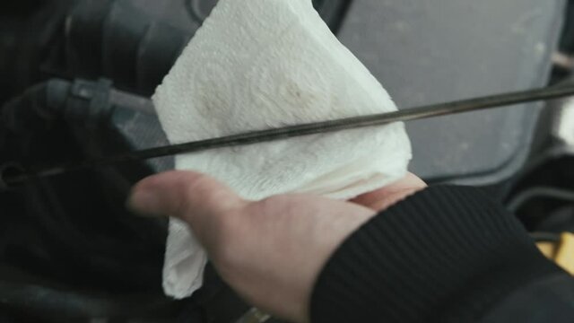 Hand Pulling Oil Dip Stick In Modern Car Engine