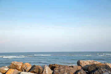 Fototapeta na wymiar The rocky beach with the sea and blue sky.