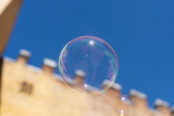Soap bubbles with reflection in the air fly against the sky