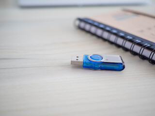 selective focus usb flash drive on table blurred  notebook background.