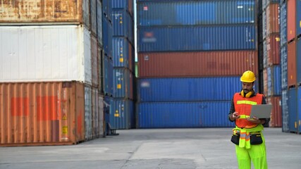 Foreman use walkie-talkie in order to control container from Cargo freight for import and export. Safety hard hat prevent accident and various equipment in industry. 