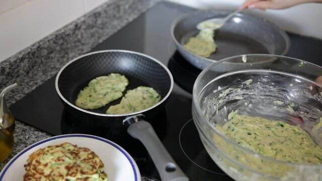Image of process frying zucchini pancakes in frying pan in kitchen. High quality FullHD footage