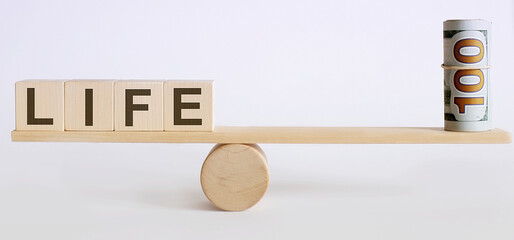 Seesaw Showing Balance Between money And word LIFE