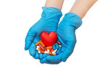 Hands in blue medical gloves holding many pills with red heart in palms. Isolated on white. Medical concept.
