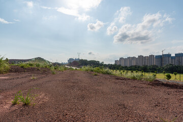 Perspective view of dirt and gravel road and buildings in the distance