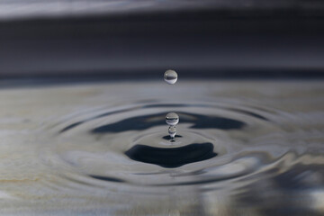Fototapeta na wymiar A small water drop fall on water surface