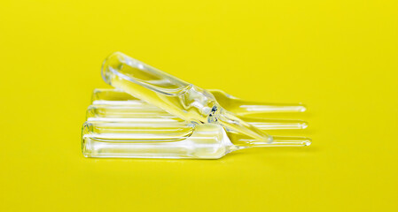 Medical ampoules close up. A lot of glass ampoules on a yellow background. Close-up. Selective focus. Medical concept.