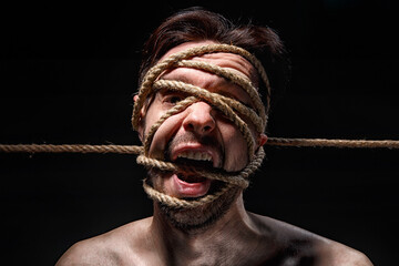 Image of binded man with rope on face