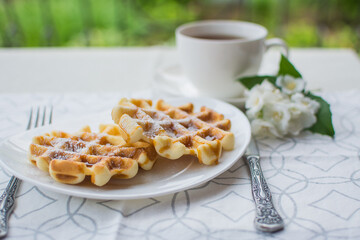 Viennese waffles. Breakfast on the terrace. Viennese waffles with caramel sauce for breakfast.
