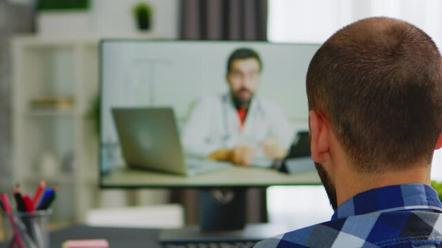 Disabled man seeking assistance from doctor during a video call. Handicapped invalid paralysed freelancer, immobilized entrepreneur working from home, ilness and disability