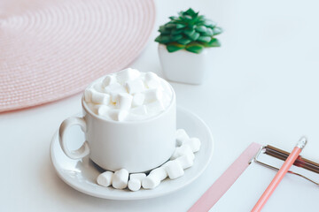 Fototapeta na wymiar Cappuccino with marshmallows and tablet folder on white background
