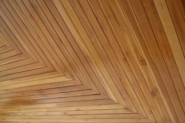 The ceiling is made of golden teak wood, lacquer is made from hand, brown color, reflecting the light and shadow. Part of a wooden house in Southeast Asia.