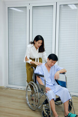 Thai woman is Caring and Take the old father sitting on wheelchair and ill health for to see a doctor at hospital in Thailand