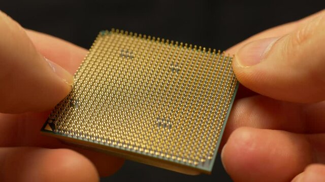 CPU macro hands holding processor (cca 2010 era PC CPU)