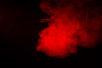 Colorful smoke close-up on a black background. Red cloud of smoke.