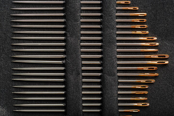 A set of sewing needles on a black background.