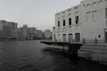 Fototapeta na wymiar Old heritage building face to face with the new buildings, A view from the shore of old Dubai, Al Seef has retained the charm of Old Dubai
