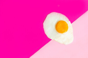 One fried egg on pink background, pop art, isolated from the right side