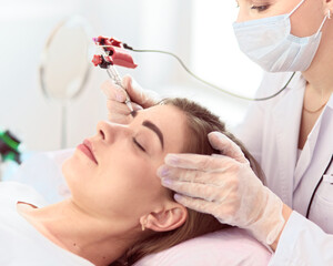 A young girl having red lips permanent makeup, micropigmentation