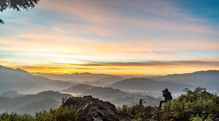 A Photographer in action during sunrise in the mountains