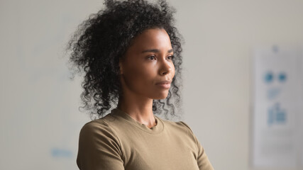 Three quarter portrait of attractive African American businesswoman in office, mixed race employee...