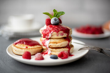 pancakes with raspberry jam, sour cream and powdered sugar