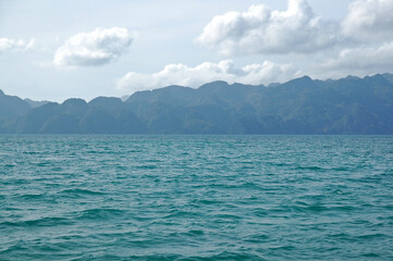 Blue turquoise water sea with mountain view and cloudy sky